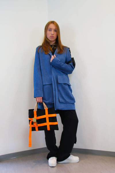 Denim Jacket with oversized pockets on the front and a small leather pocket/bag on the arm.