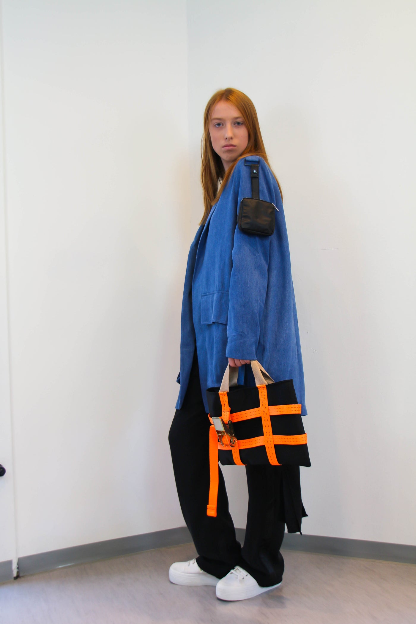 Denim Jacket with oversized pockets on the front and a small leather pocket/bag on the arm.